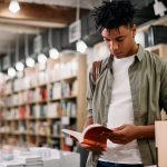 young black student reading a book in a library 2023 11 27 05 00 23 utc