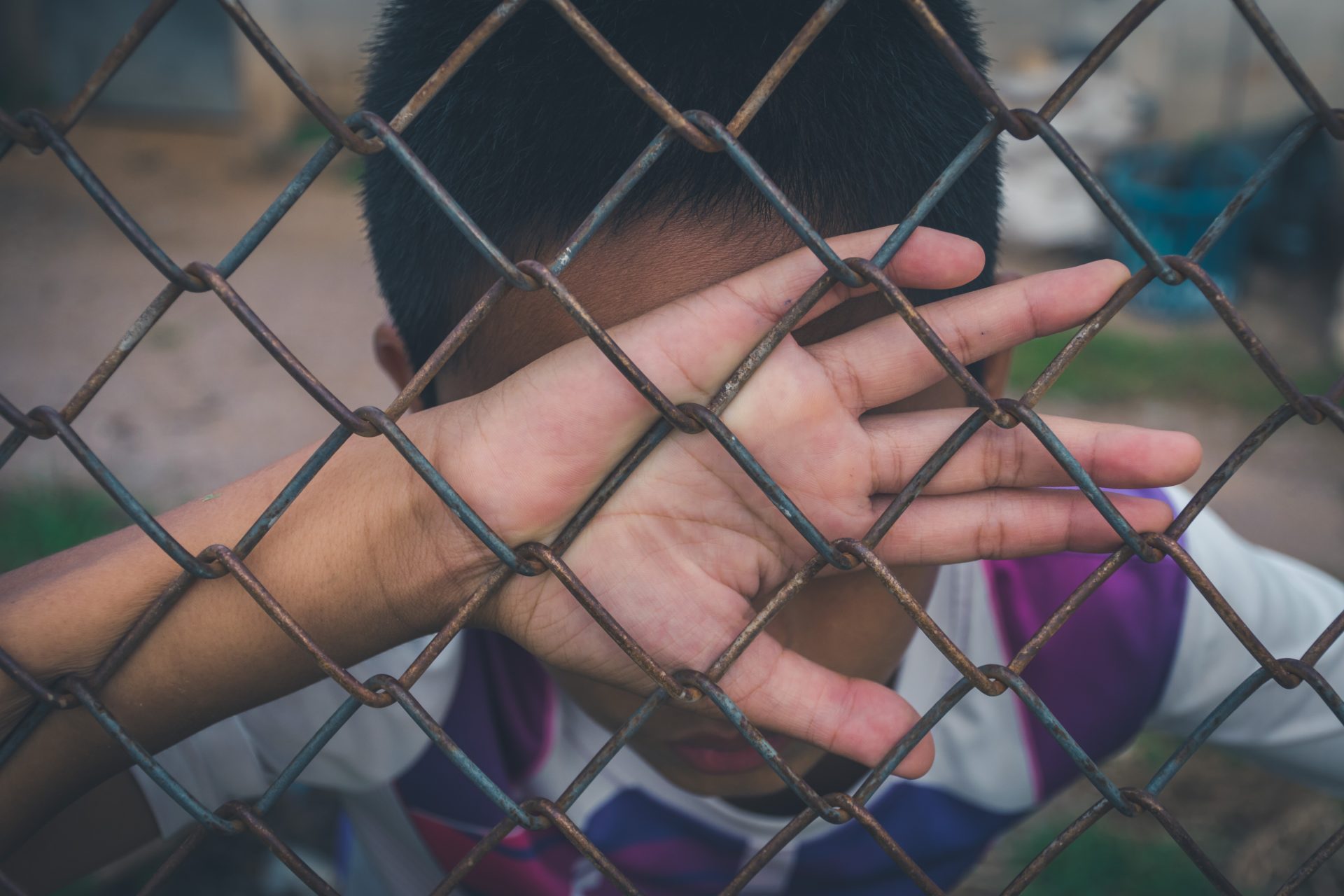 asian boy holding metal fence and crying alone 2023 11 27 05 02 20 utc