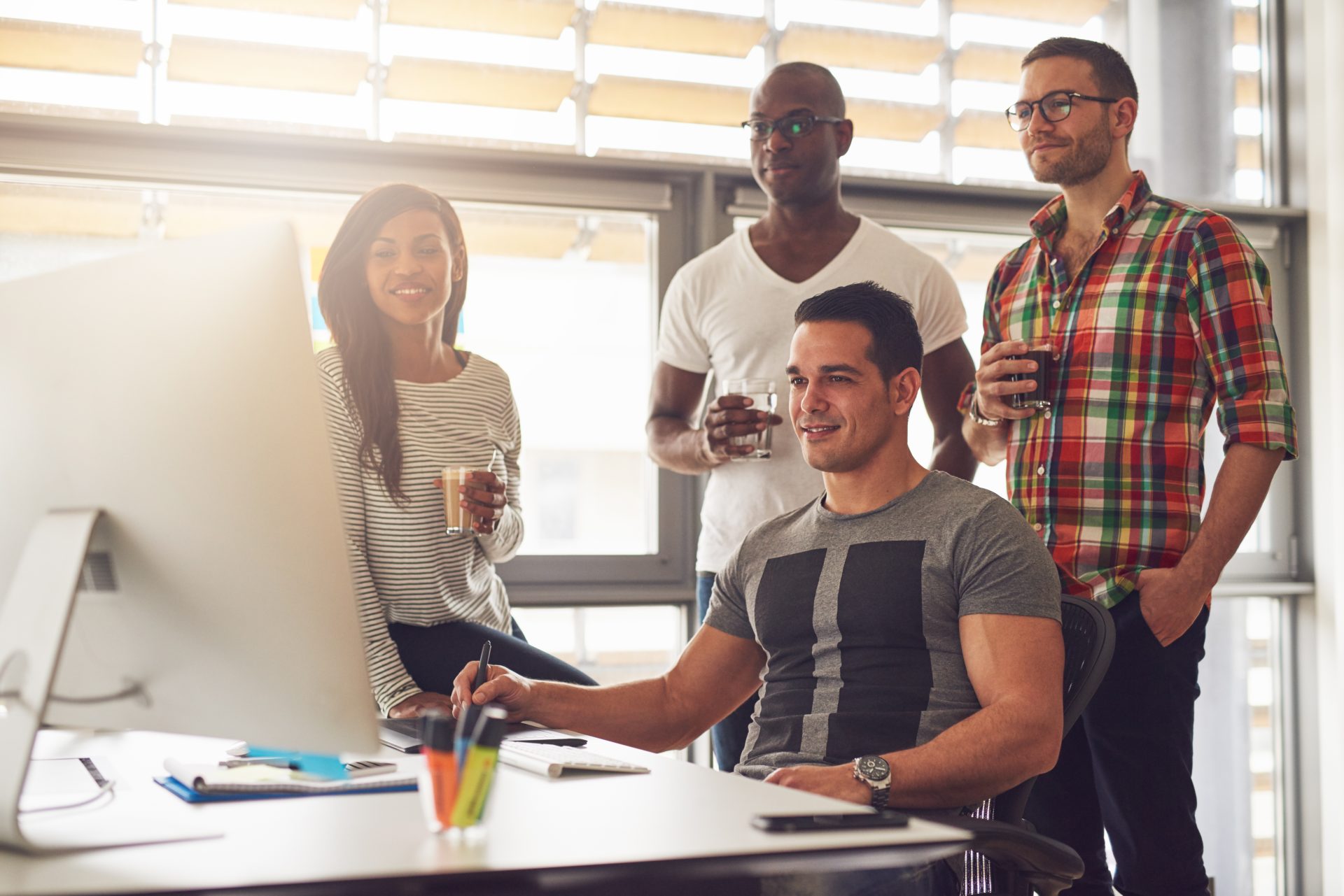 relaxed young workers around computer in office 2023 11 27 05 11 47 utc