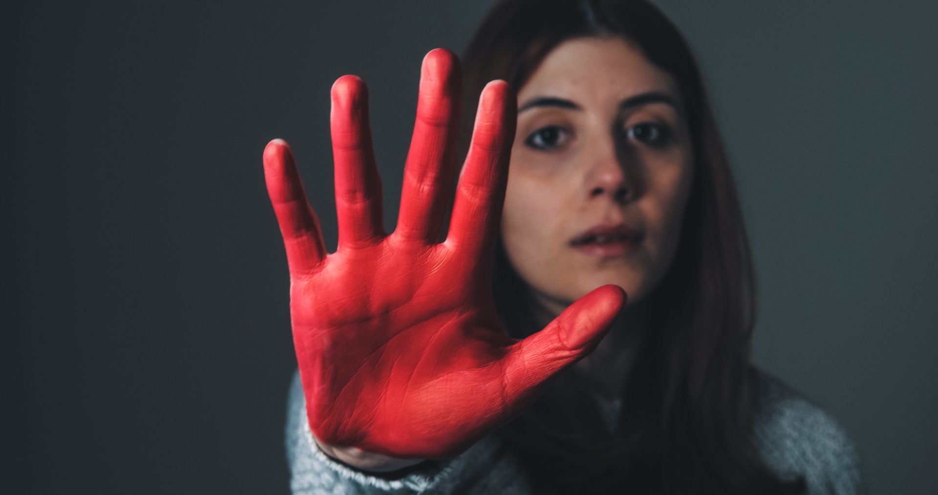 sad girl raises her hand painted red to stop and p 2023 11 27 04 53 45 utc