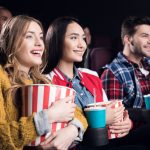 young smiling friends with popcorn watching film i 2023 11 27 05 09 21 utc