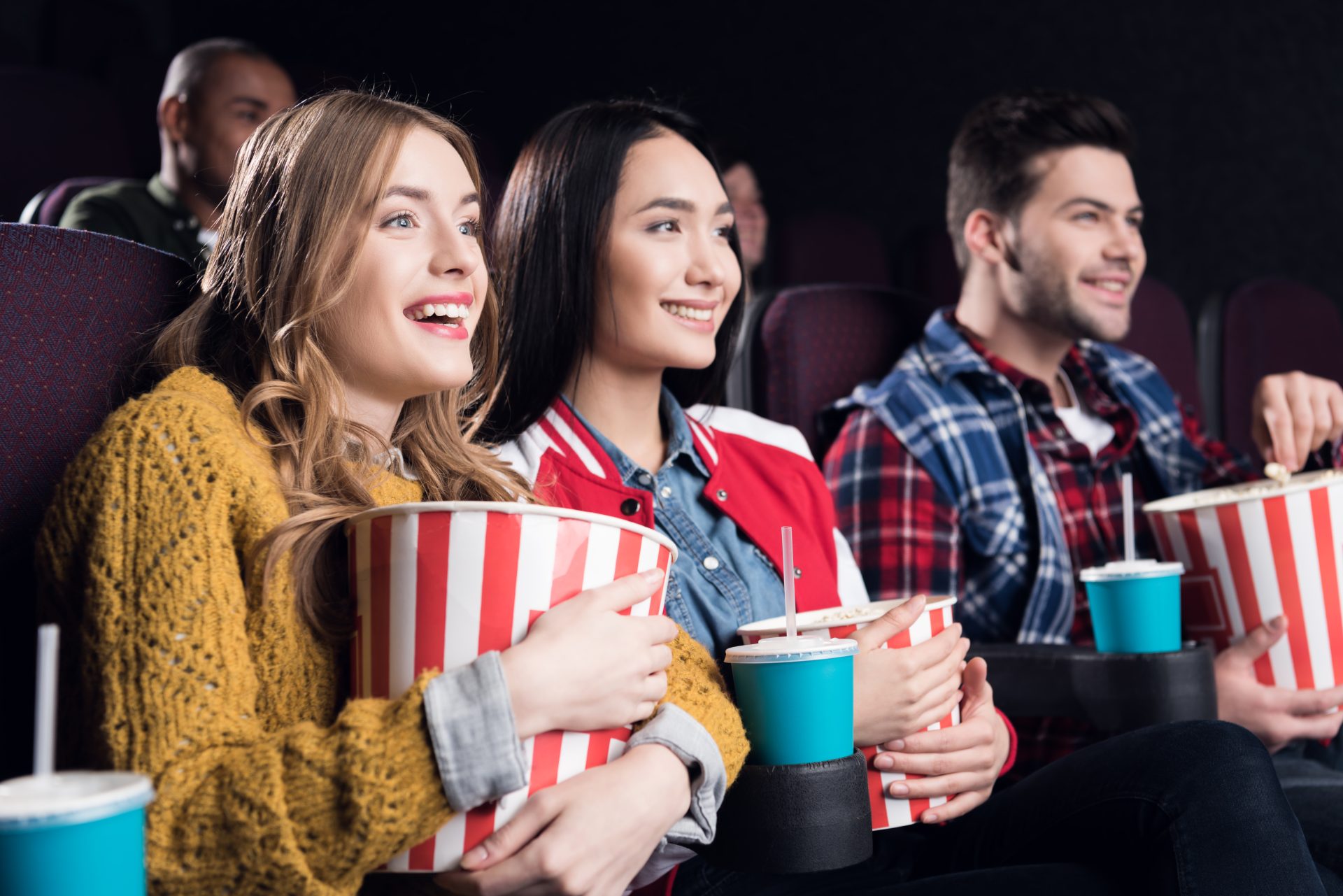young smiling friends with popcorn watching film i 2023 11 27 05 09 21 utc