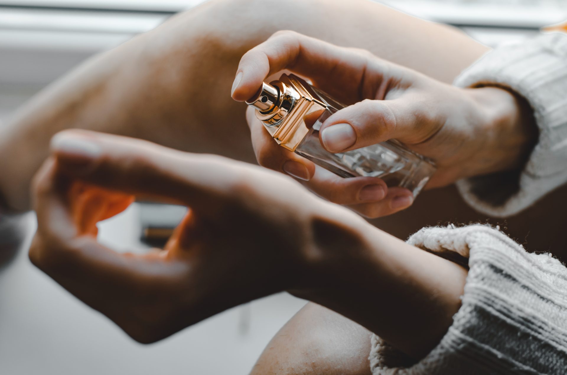 young woman sprinkles perfume on her wrist perfum 2023 11 27 05 18 22 utc