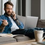bearded man talking on cellphone and using laptop 2023 11 27 05 14 51 utc