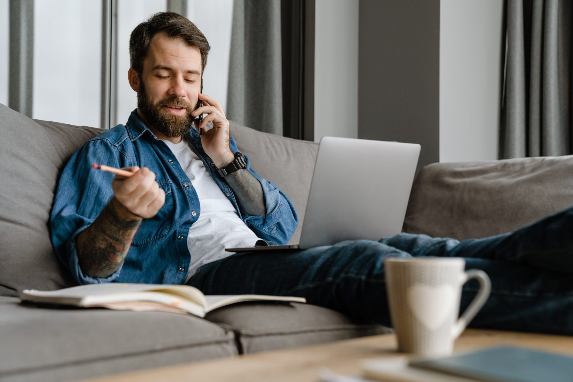 bearded man talking on cellphone and using laptop 2023 11 27 05 14 51 utc