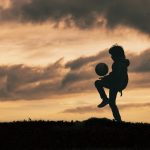 child in silhouette dribbles and plays with soccer 2023 11 27 05 10 28 utc