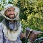 beekeeper in a protective mask smiling 2024 07 10 04 48 36 utc