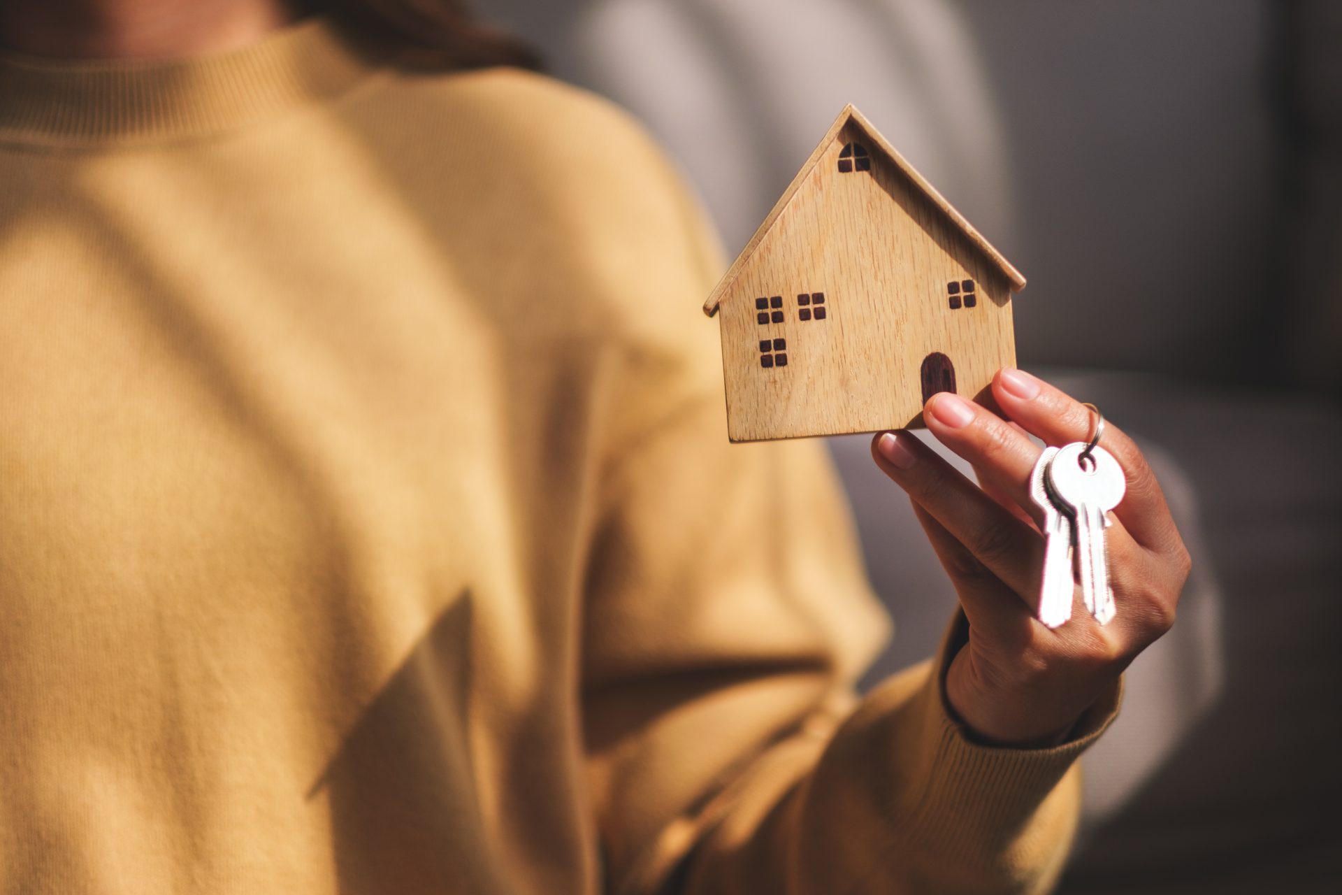 closeup image of a woman holding a wooden house mo 2024 07 23 22 40 56 utc