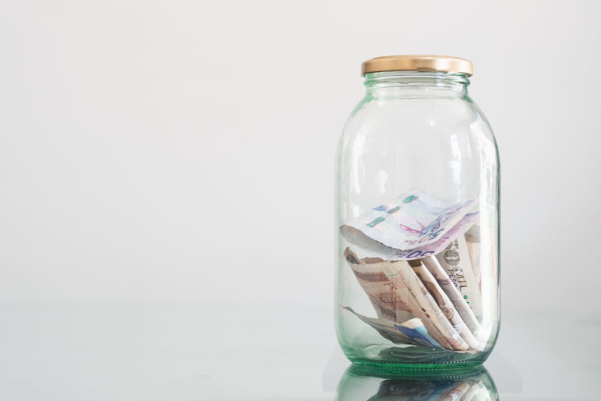 colombian banknotes in glass jar on glass table 2023 11 27 05 17 15 utc