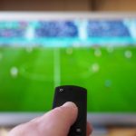 hand pointing remote control at tv with soccer mat 2023 11 27 05 30 16 utc