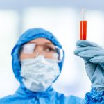 medic in hazmat protective suit holds a test tube 2023 11 27 04 59 09 utc