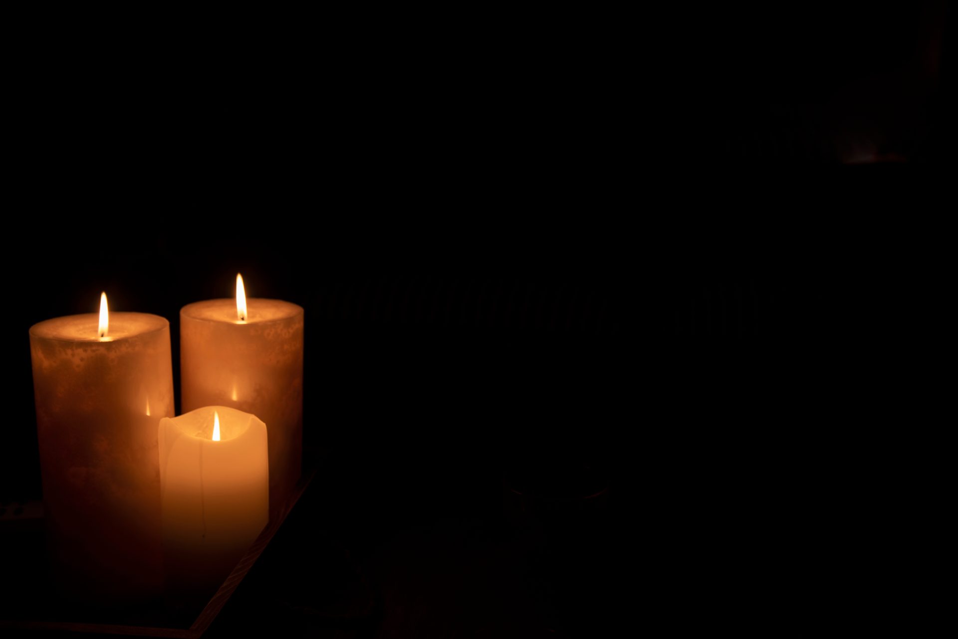 three candles burning at night in dark home 2023 11 27 05 35 35 utc