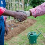 two african peasants shake hands while working in 2023 11 27 05 28 22 utc
