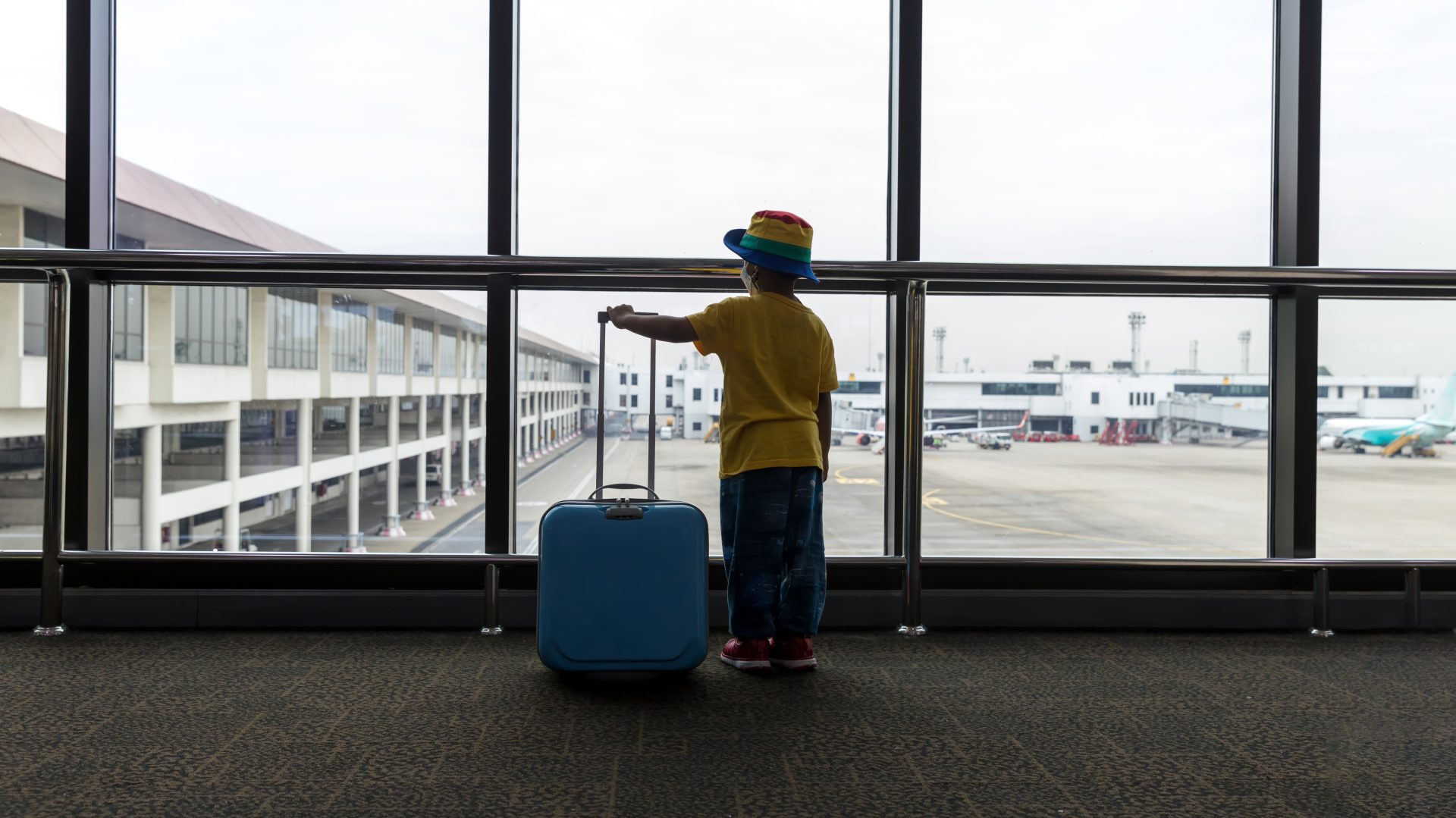 child with suitcase at airport terminal waiting fo 2024 08 05 21 17 02 utc