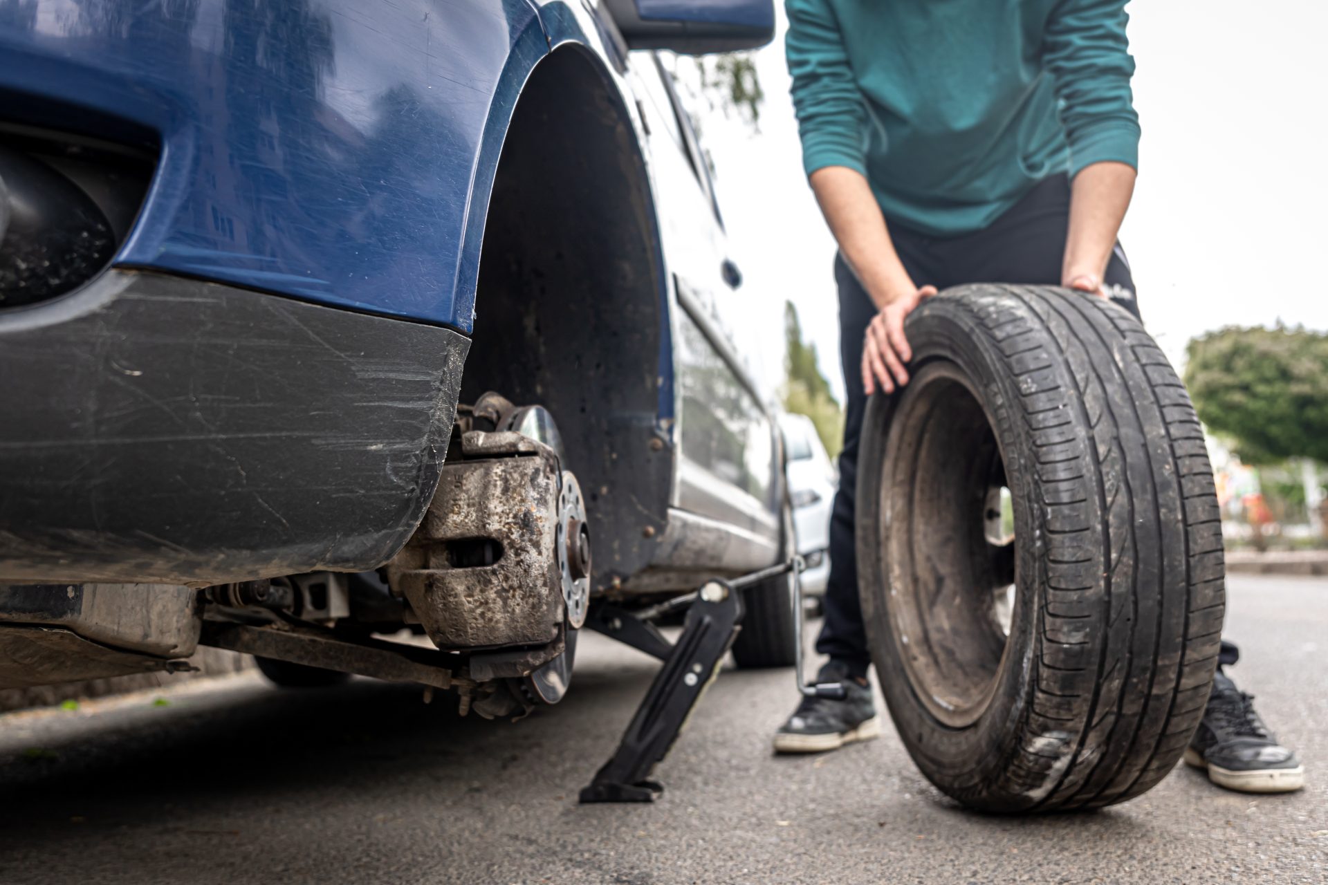 close up a man changes a tire in a car on the road 2023 11 27 05 05 38 utc
