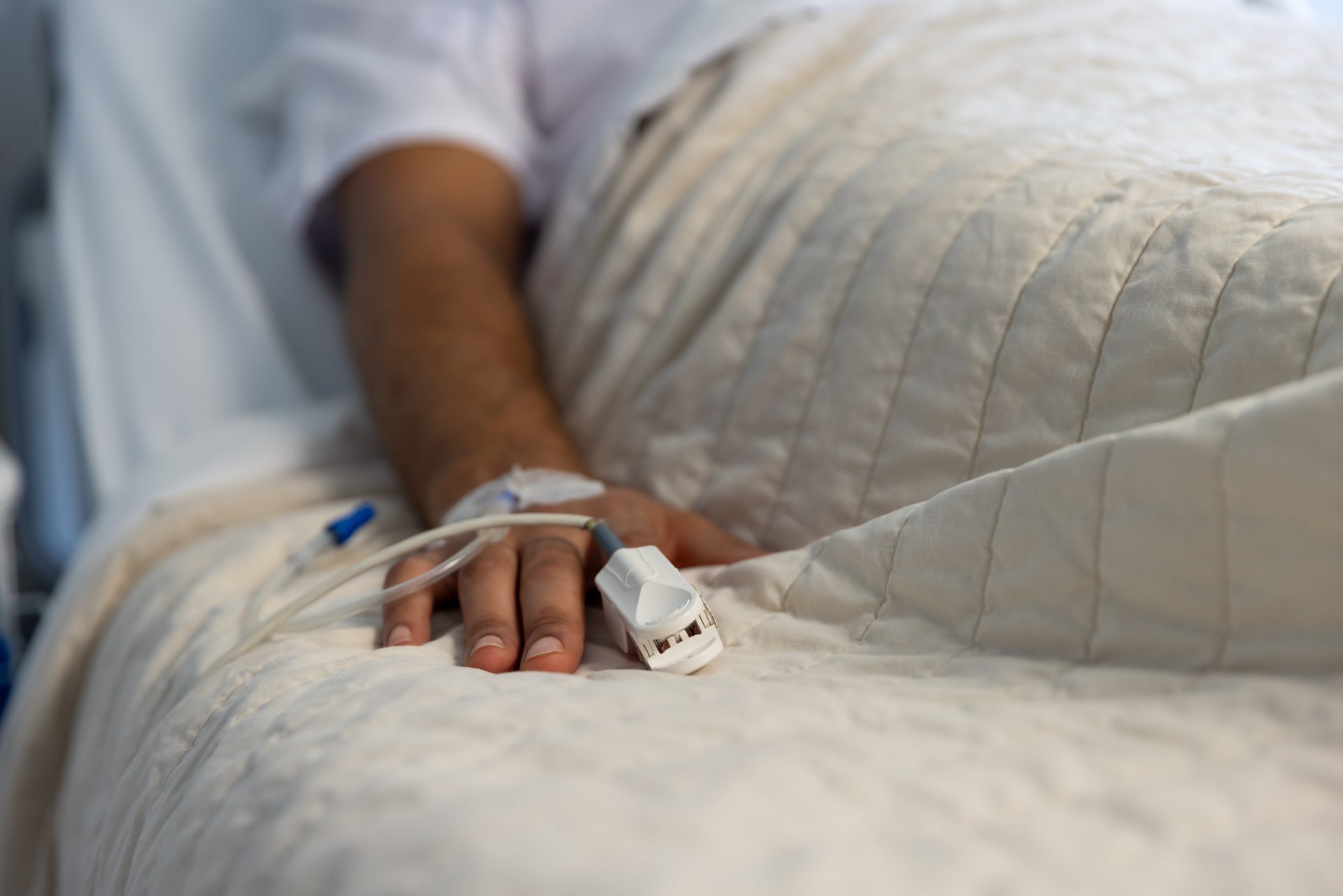 hand of biracial male patient with iv drip lying i 2023 11 29 04 47 55 utc