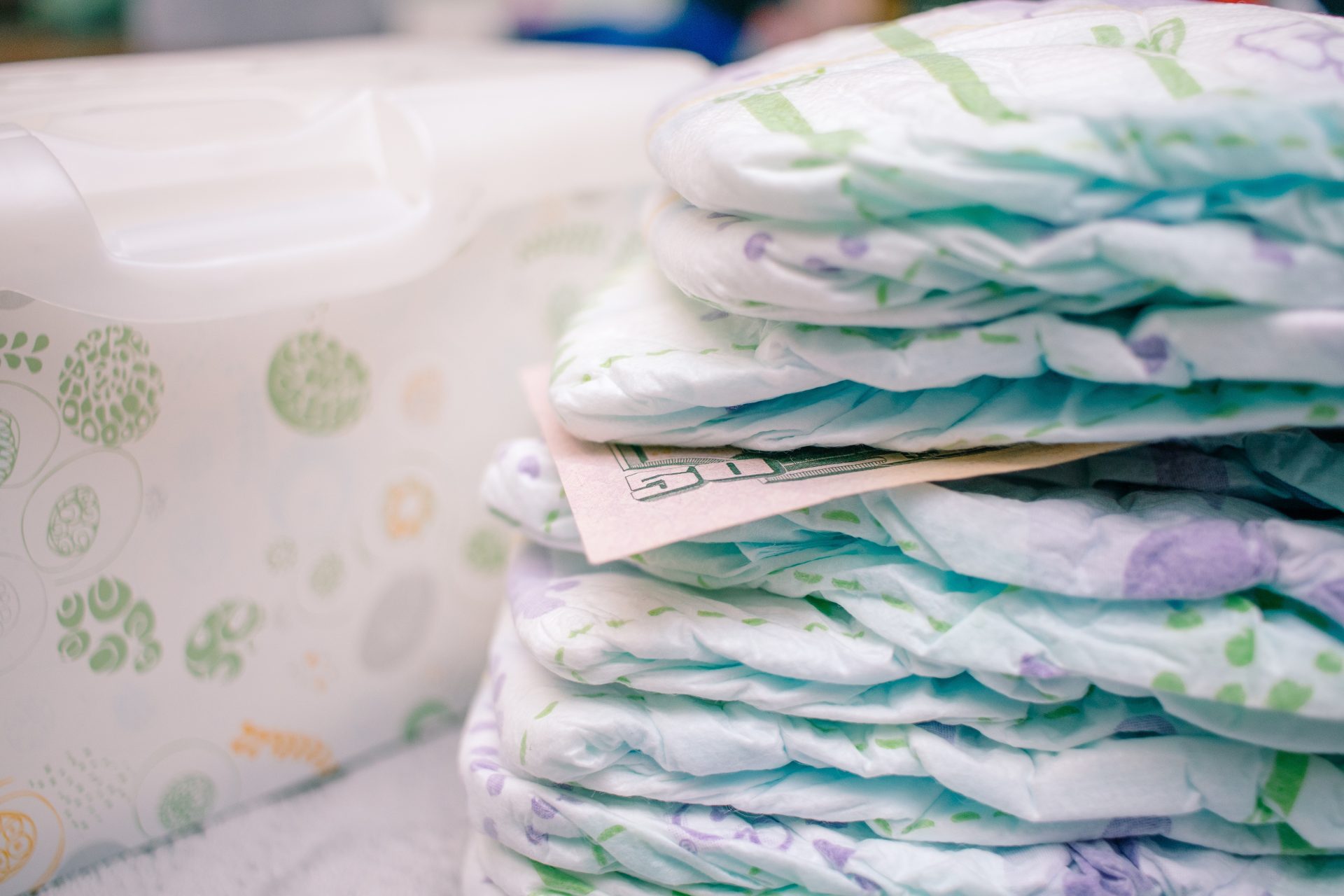 a stack of diapers with a fifty dollar bill in the 2024 09 14 06 16 56 utc