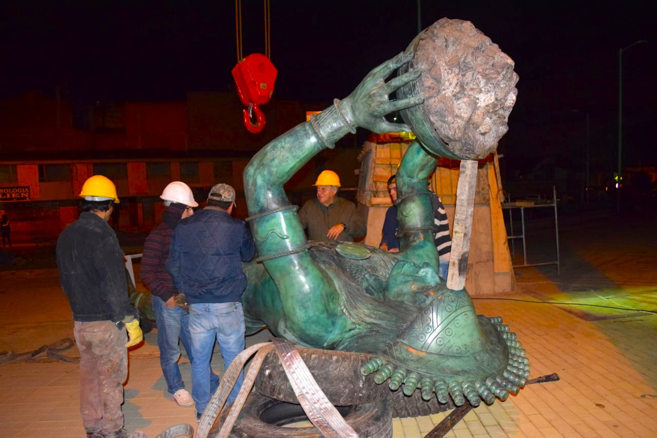 El maestro Antonio Frío, escultor del Tisquesusa (Casco amarillo, entre los brazos de la escultura), coordinando la colocada de su obra en el pedestal.