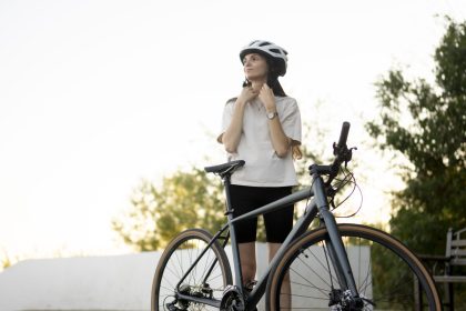 a woman adjusts and puts on her bike helmet before 2025 01 26 23 42 16 utc