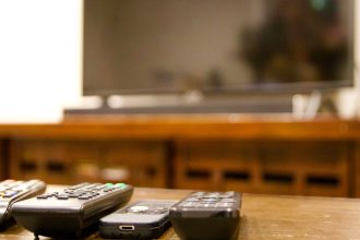 multiple remote controls lined up with tv in backg 2026 01 05 23 25 55 utc