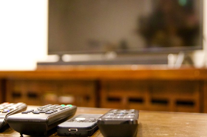 multiple remote controls lined up with tv in backg 2026 01 05 23 25 55 utc