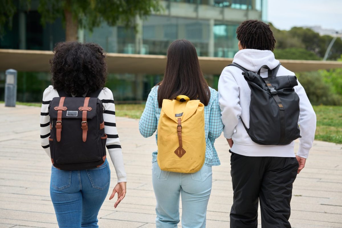 three young students walking down a sidewalk to th 2026 03 19 22 08 10 utc