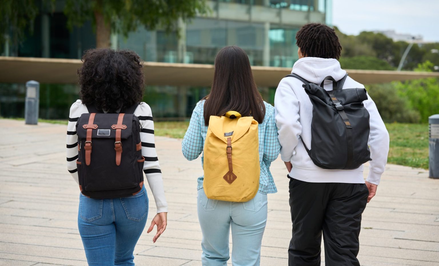 three young students walking down a sidewalk to th 2026 03 19 22 08 10 utc