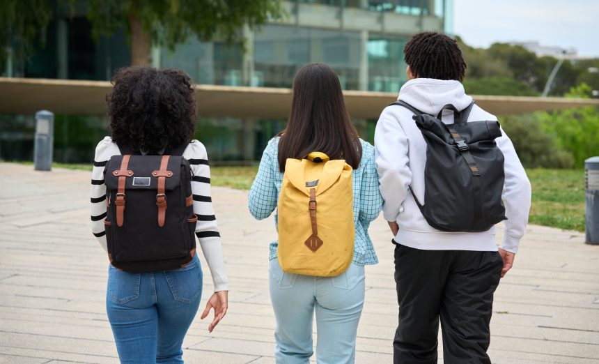 three young students walking down a sidewalk to th 2026 03 19 22 08 10 utc