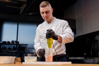 a chef in a white jacket mixes salad dressing with 2026 03 16 01 20 36 utc