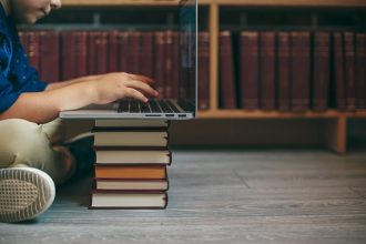 laptop on a stack of books 2026 03 09 09 17 19 utc