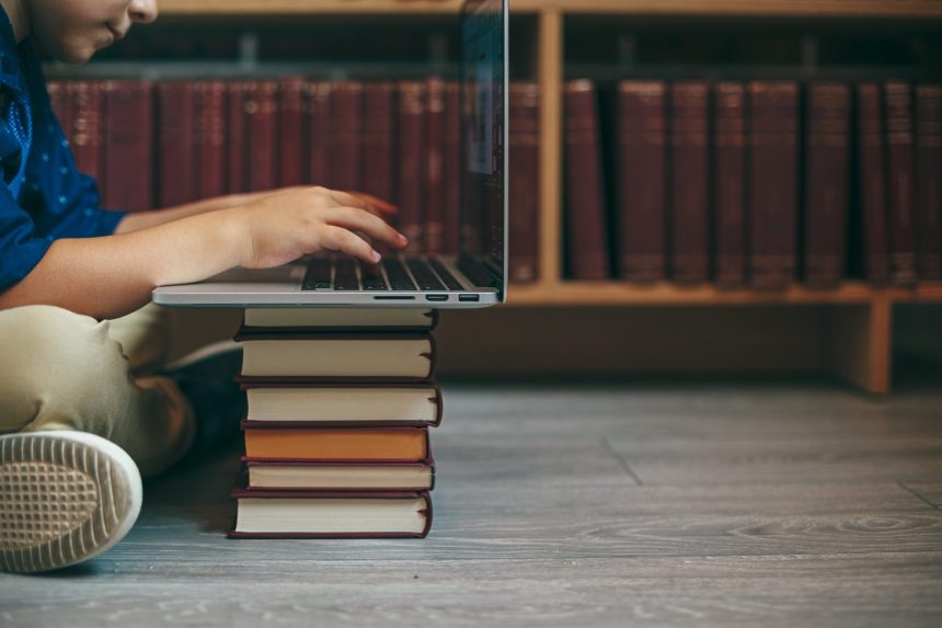 laptop on a stack of books 2026 03 09 09 17 19 utc
